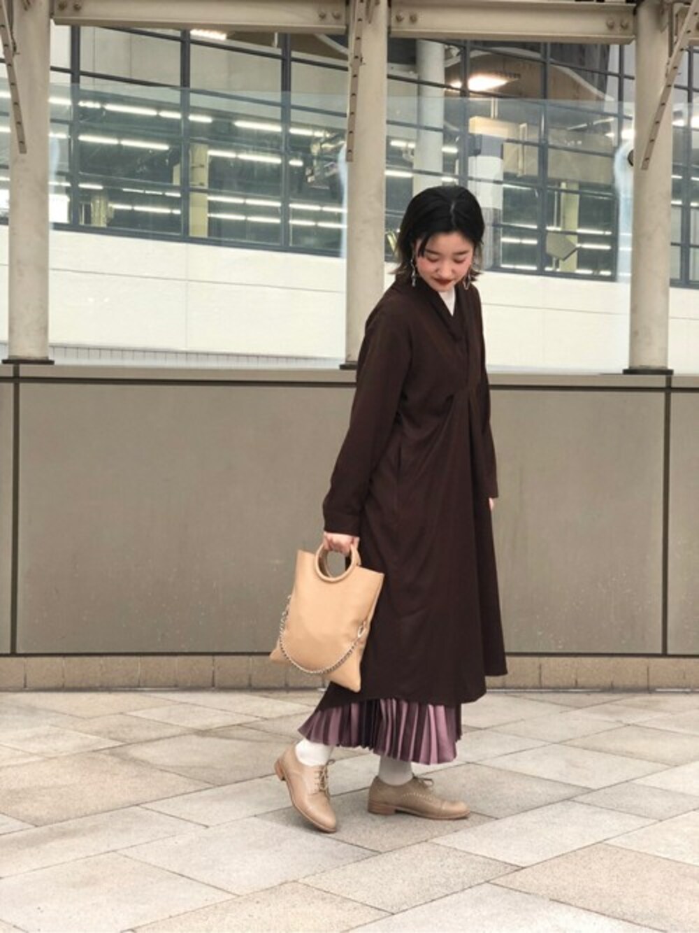 ベージュ系のショルダーバッグ、ブラウン系のスカート、ブラウン系のワンピースを着用したレディースの冬コーディネートの1枚目の写真