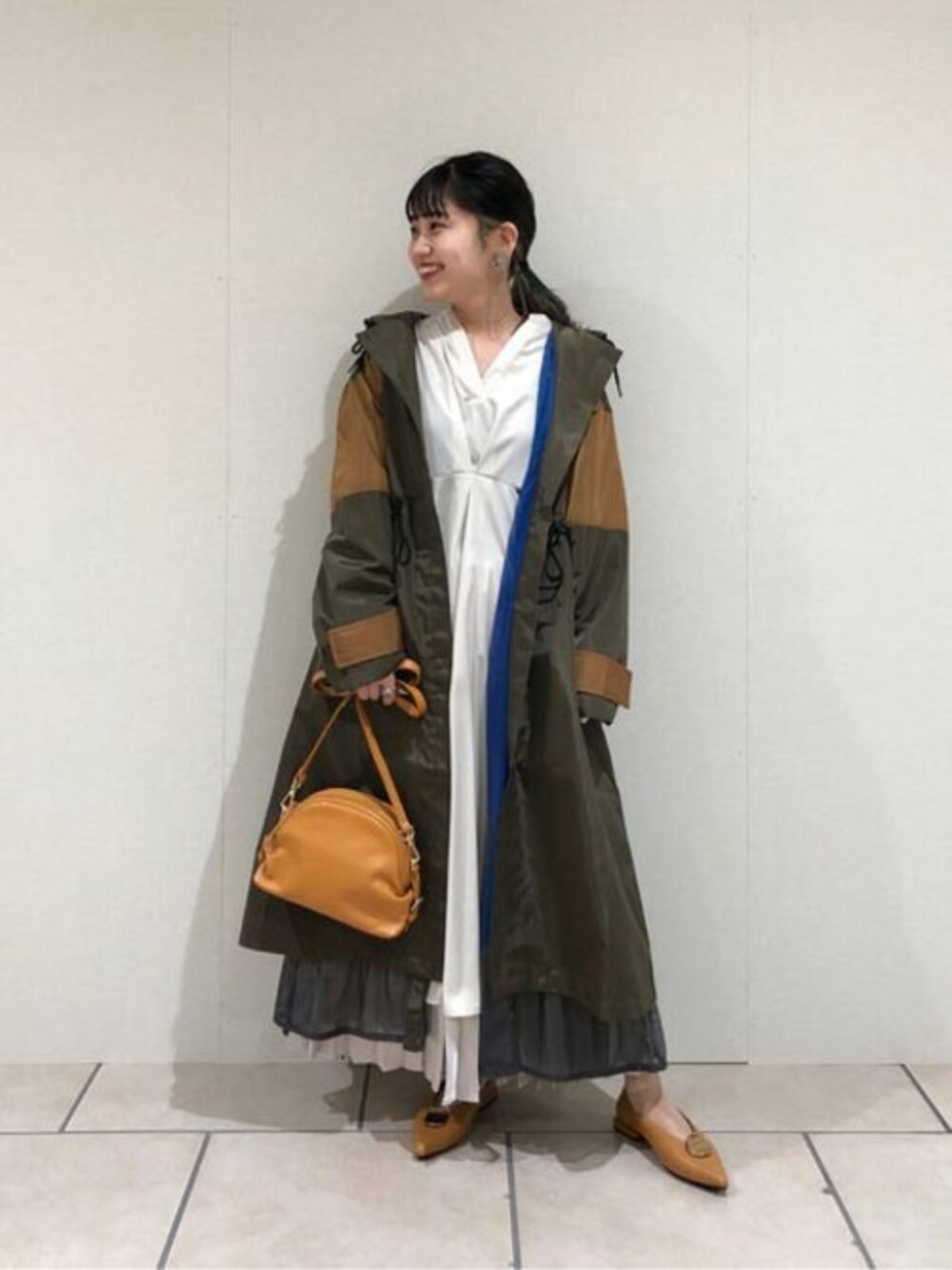 ブラウン系のパンプス、ブラウン系のショルダーバッグ、グリーン系のその他アウターを着用したレディースの冬コーディネートの1枚目の写真