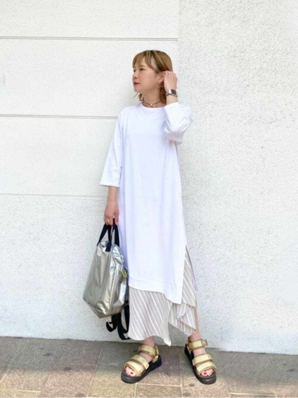 ゴールド系のサンダル、ホワイト系のワンピース、シルバー系のバックパック/リュックを着用したレディースの春コーディネートの1枚目の写真