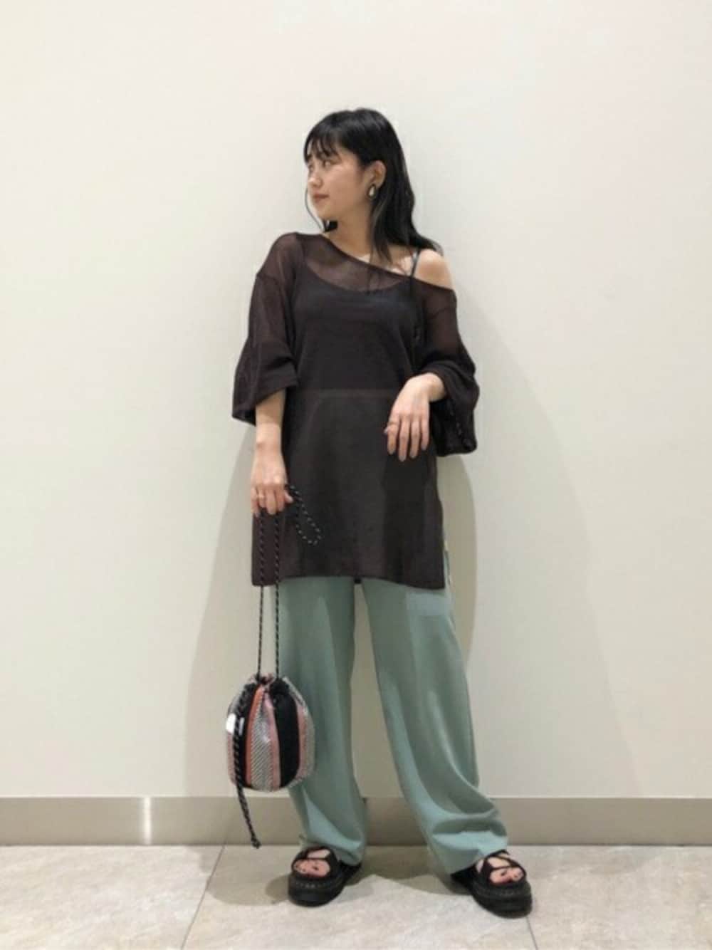 ブラック系のショルダーバッグ、ブラウン系のニット/セーター、グリーン系のキャミソールを着用したレディースの夏コーディネートの1枚目の写真