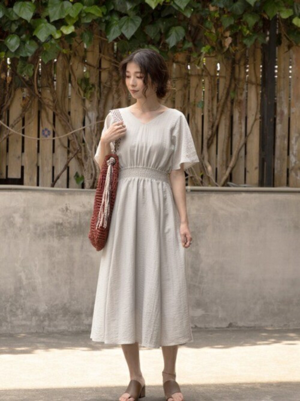 ベージュ系のワンピース、ブラウン系のショルダーバッグ、グリーン系のサンダルを着用したレディースの夏コーディネートの1枚目の写真