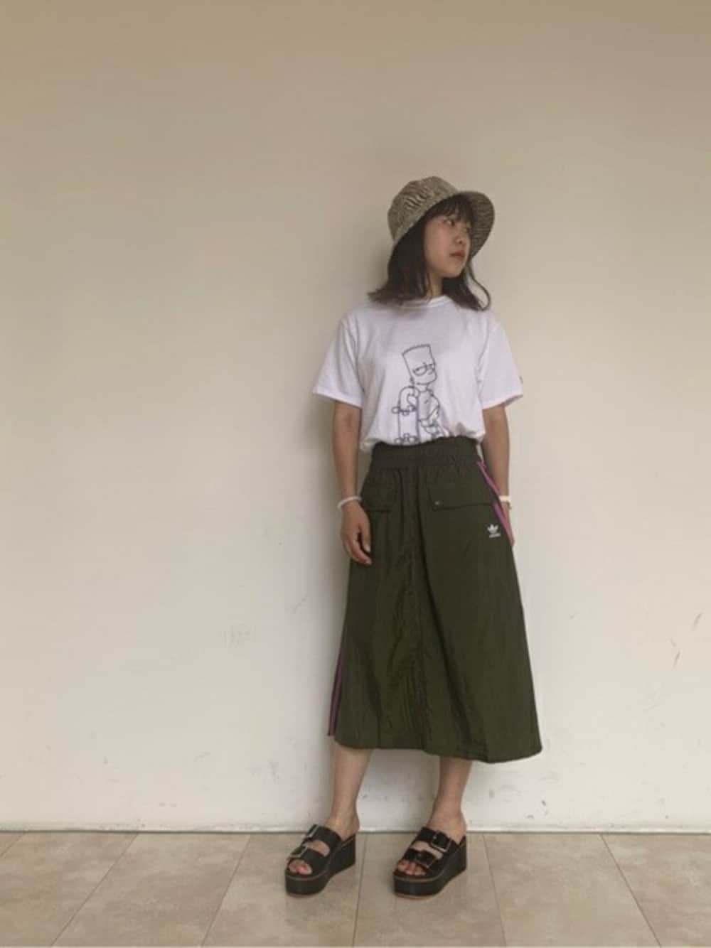 ホワイト系のTシャツ/カットソー、グリーン系のスカート、ブラック系のサンダルを着用したレディースの夏コーディネートの1枚目の写真