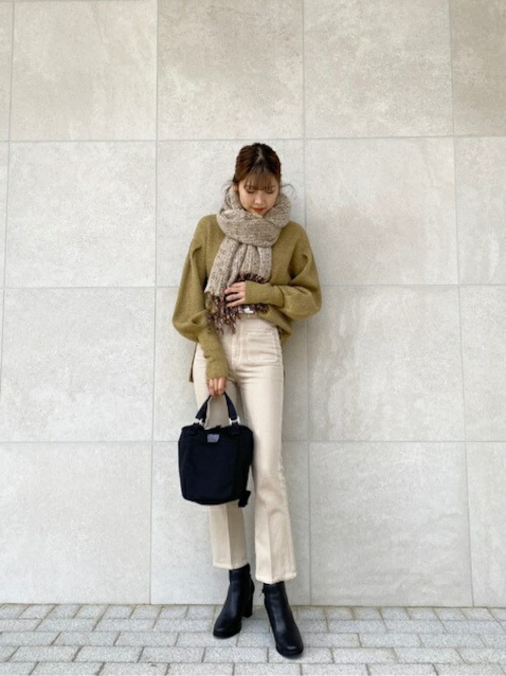 ブラック系のブーツ、ブラック系のショルダーバッグ、グリーン系のニット/セーターを着用したレディースの冬コーディネートの1枚目の写真