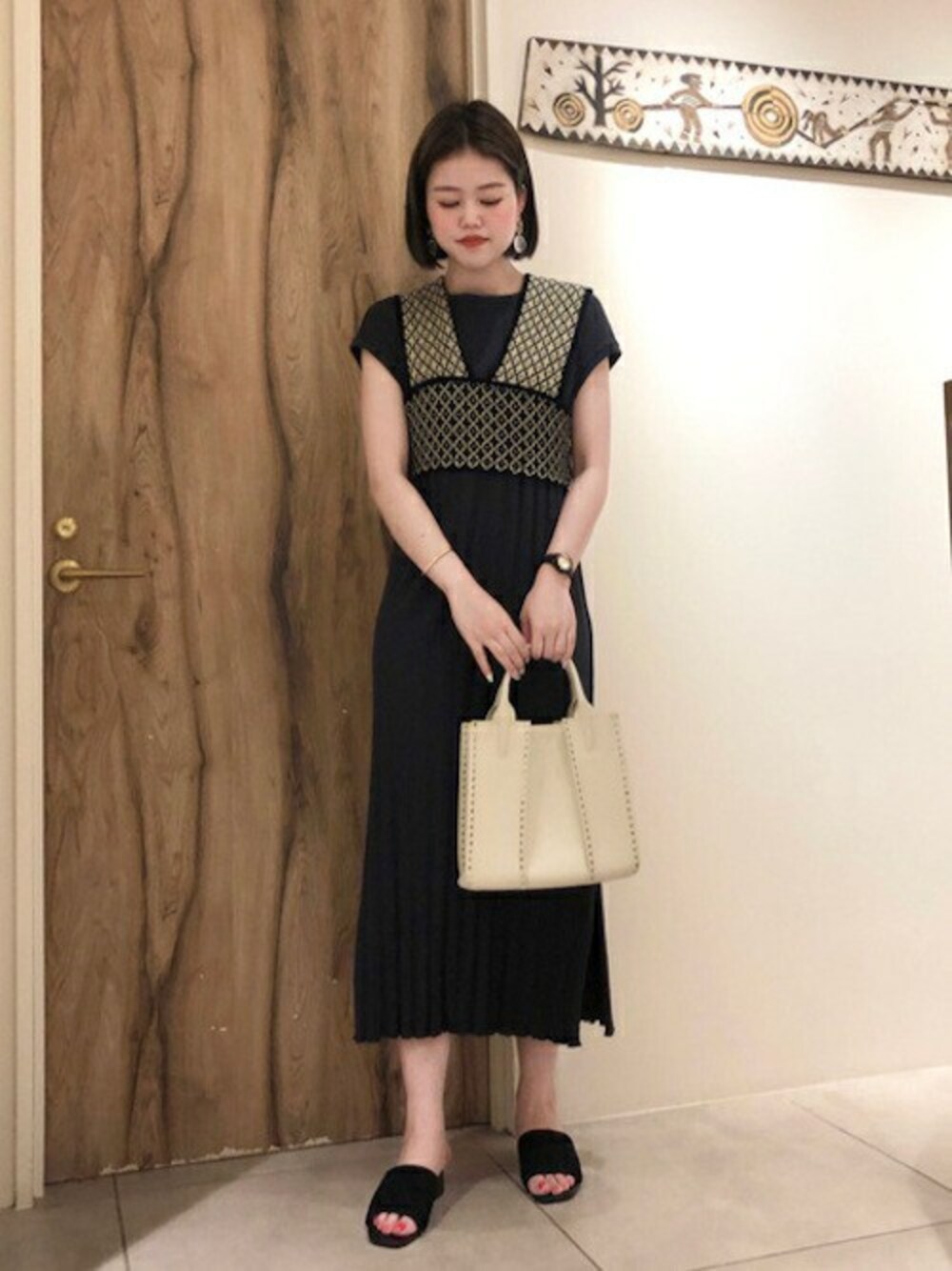 グレー系のワンピース、グレー系のショルダーバッグ、ブラック系のサンダルを着用したレディースの夏コーディネートの1枚目の写真