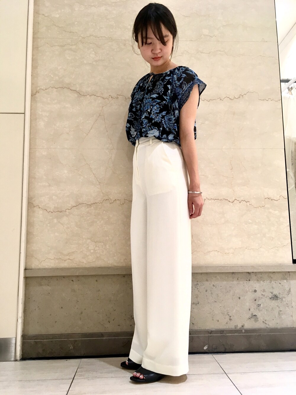 ブラック系のトップス、ホワイト系のパンツ、ブラック系のサンダルを着用したレディースの夏コーディネートの1枚目の写真