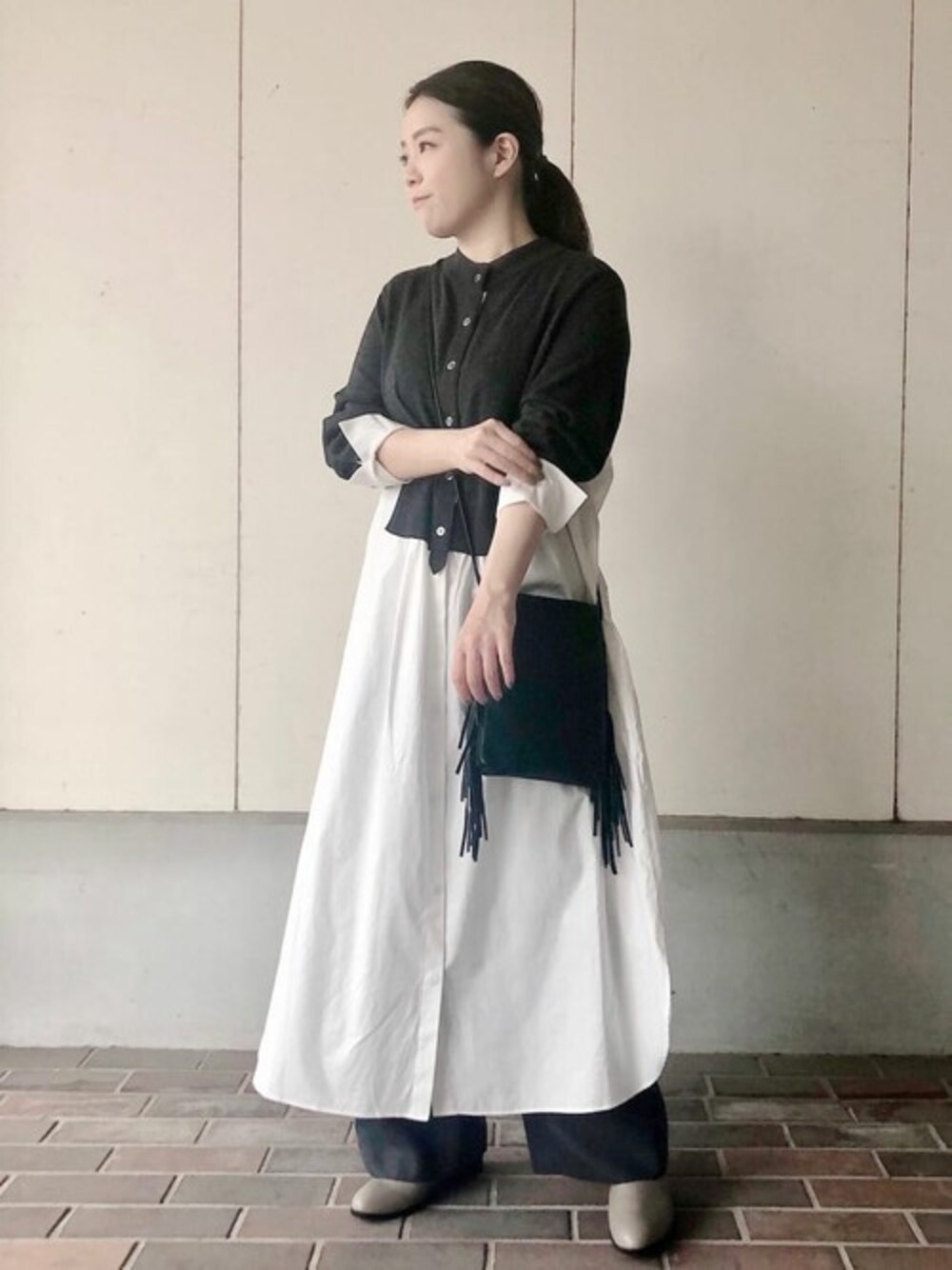 グレー系のワンピース、グレー系のその他パンツ、ブラック系のハンドバッグを着用したレディースの秋コーディネートの1枚目の写真