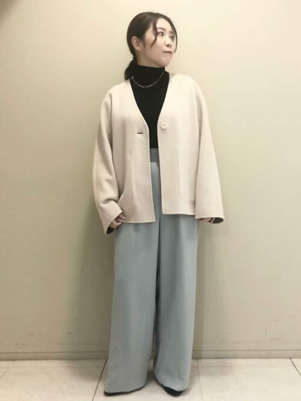 ホワイト系のノーカラーコート、ブラック系のニット/セーター、グリーン系のその他パンツを着用したレディースの秋コーディネートの1枚目の写真