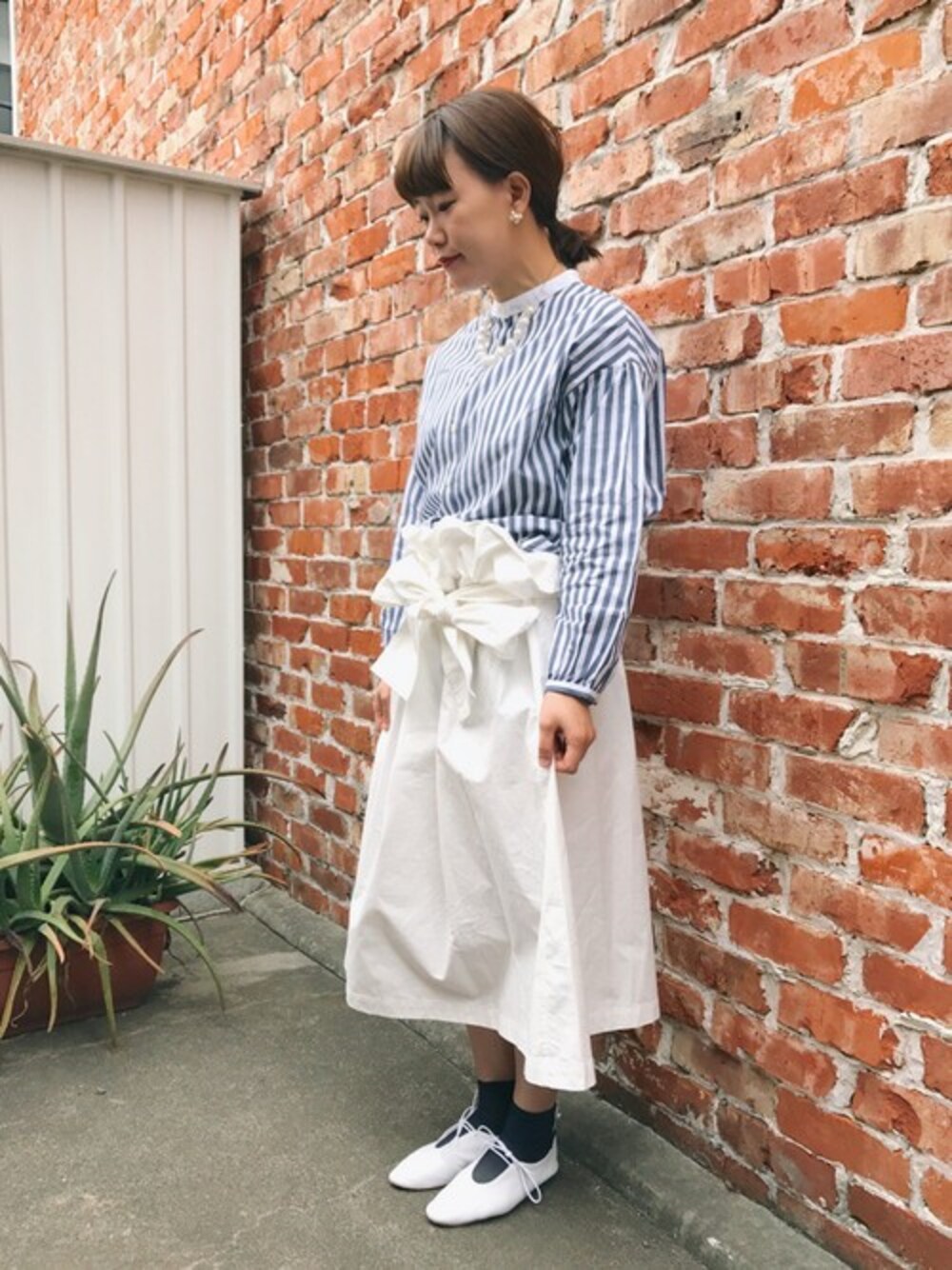 ブルー系のシャツ/ブラウスを着用したレディースの春コーディネートの1枚目の写真