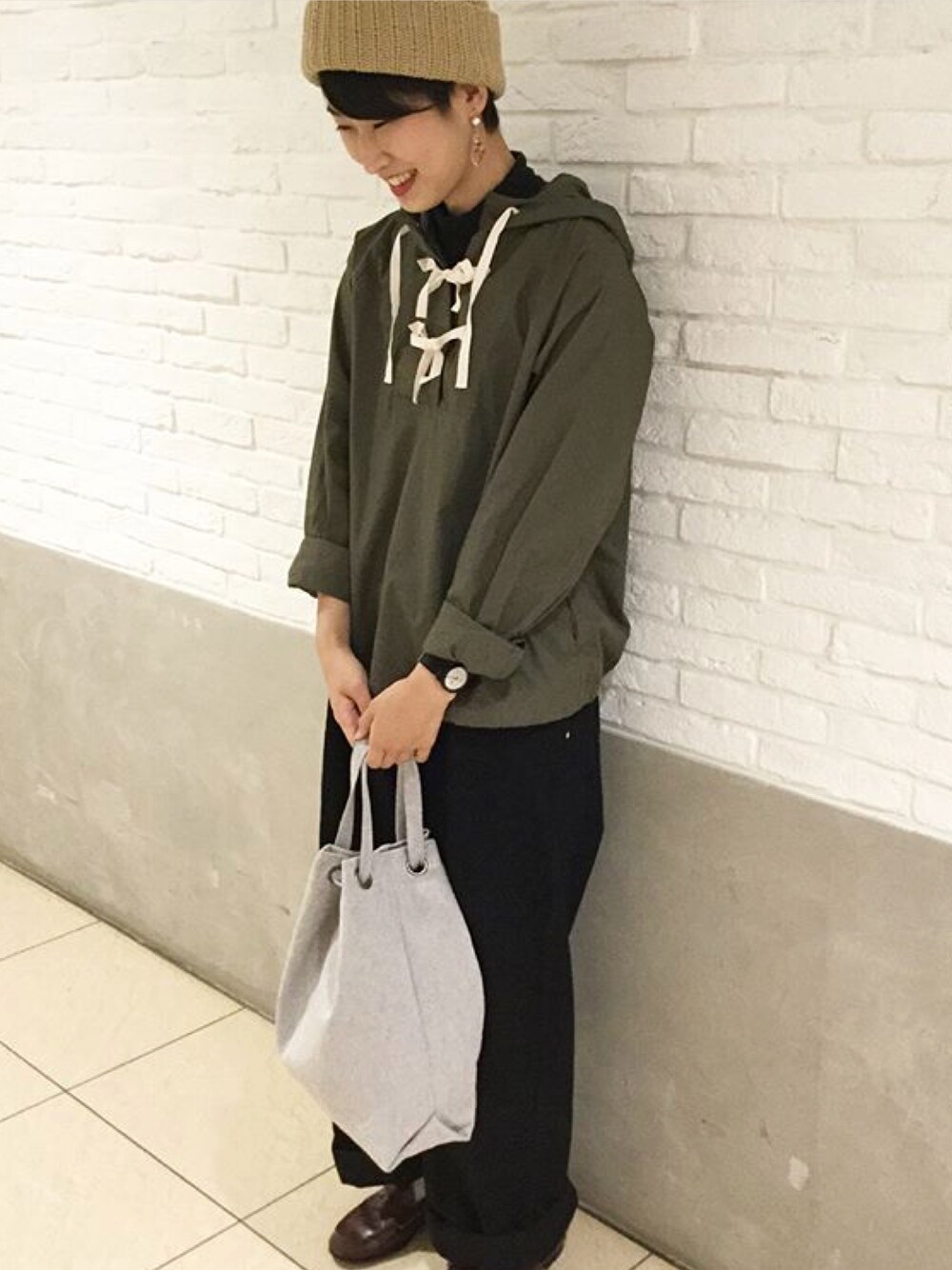 グリーン系のパーカー、ブラック系のデニムパンツ、ブルー系のトートバッグを着用したレディースの夏コーディネートの1枚目の写真