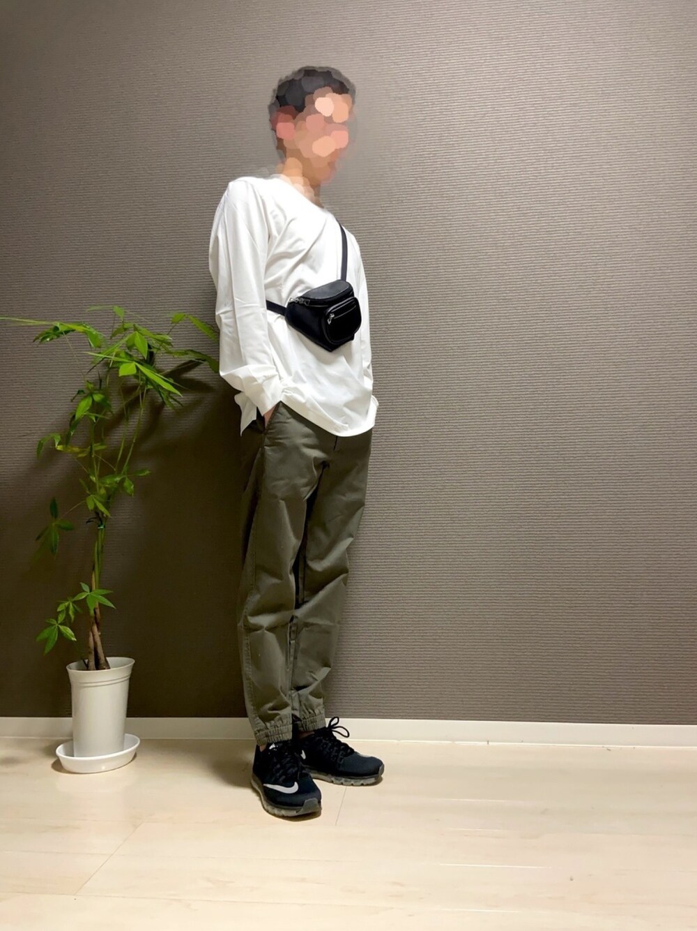 ホワイト系のTシャツ/カットソー、ブラック系のボディバッグ/ウエストポーチ、グリーン系のチノパンツを着用したメンズの冬コーディネートの1枚目の写真