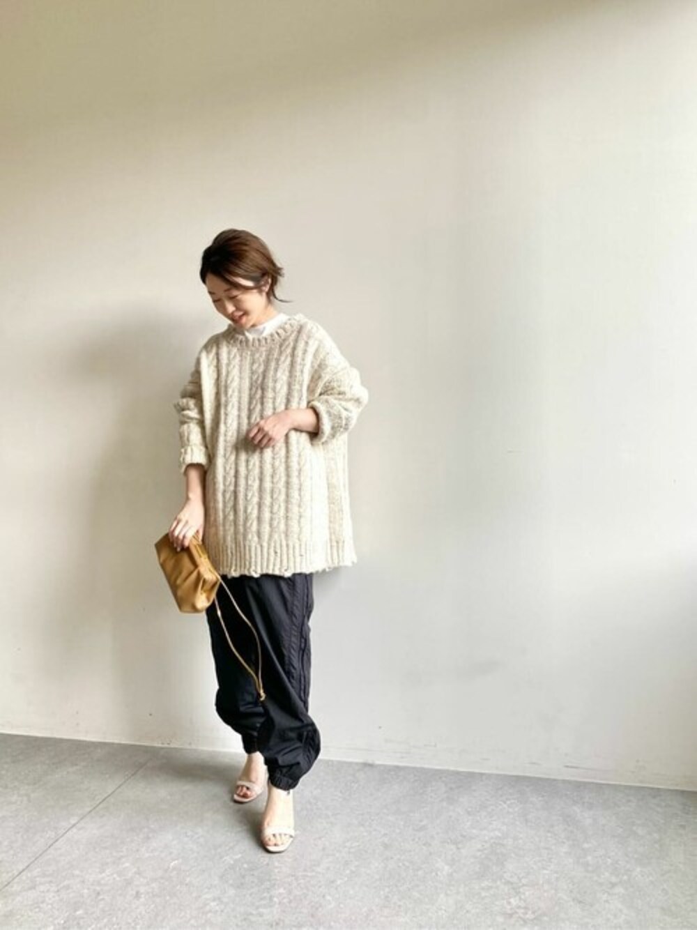 ベージュ系のニット/セーター、ホワイト系のシャツ/ブラウスを着用したレディースの秋コーディネートの1枚目の写真