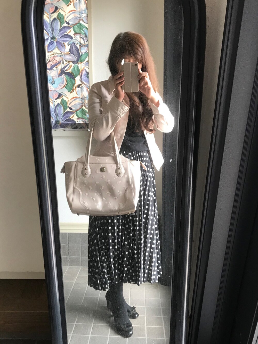 ピンク系のハンドバッグ、ブラック系のスカート、ピンク系のデニムジャケットを着用したレディースの春コーディネートの1枚目の写真