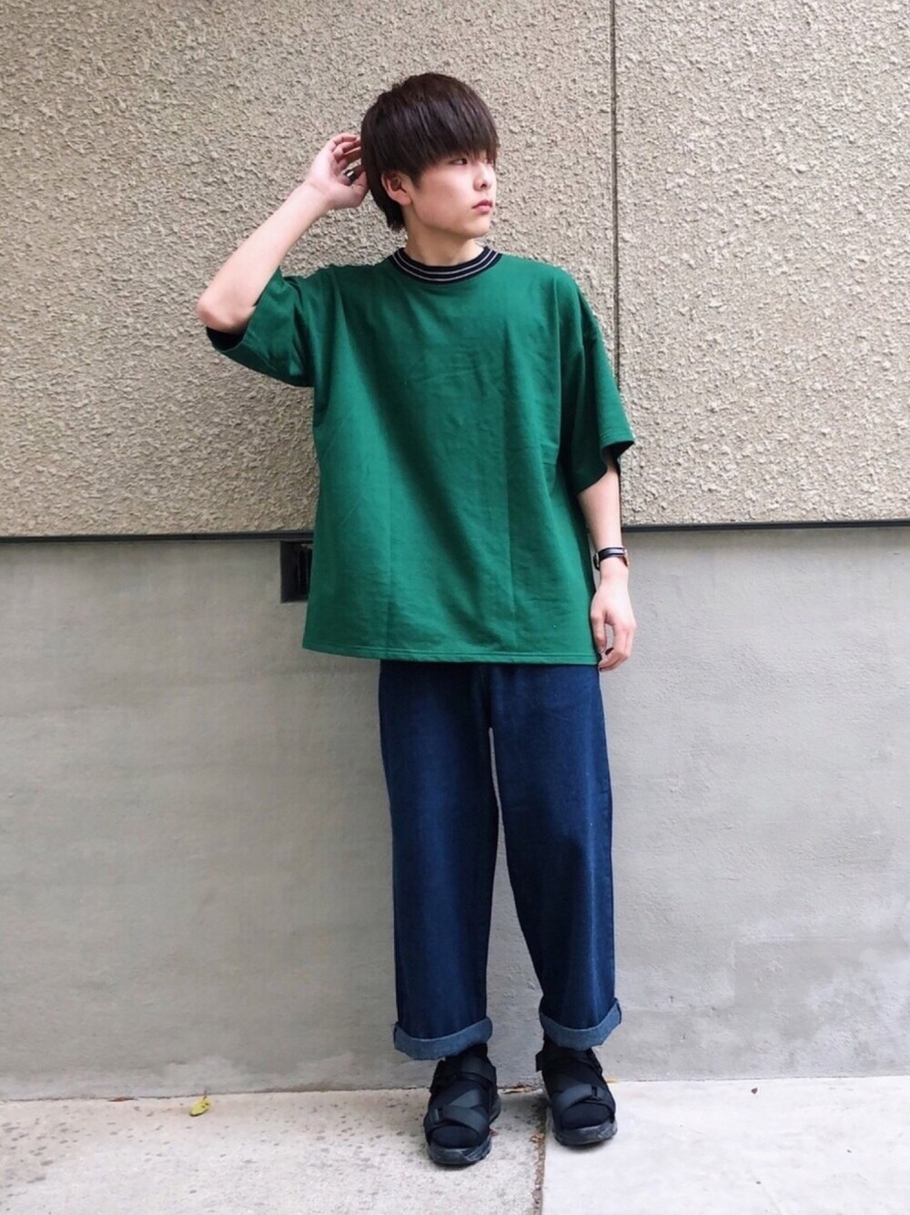 グリーン系のTシャツ/カットソー、ブルー系のデニムパンツ、ブラック系のサンダルを着用したメンズの春コーディネートの1枚目の写真