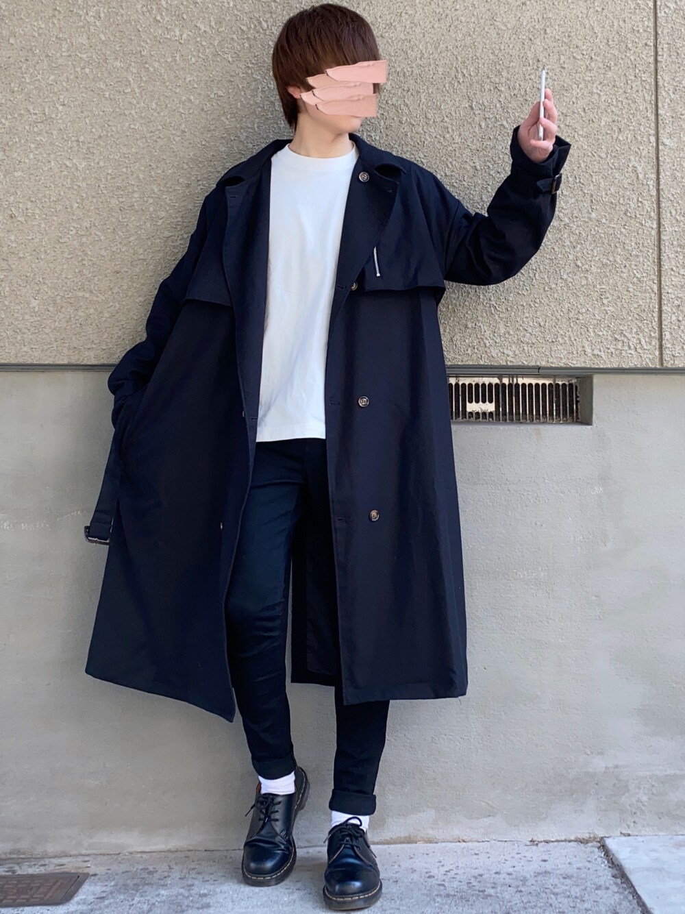 ブラック系のトレンチコート、ホワイト系のTシャツ/カットソー、ブラック系のパンツを着用したメンズの春コーディネートの1枚目の写真