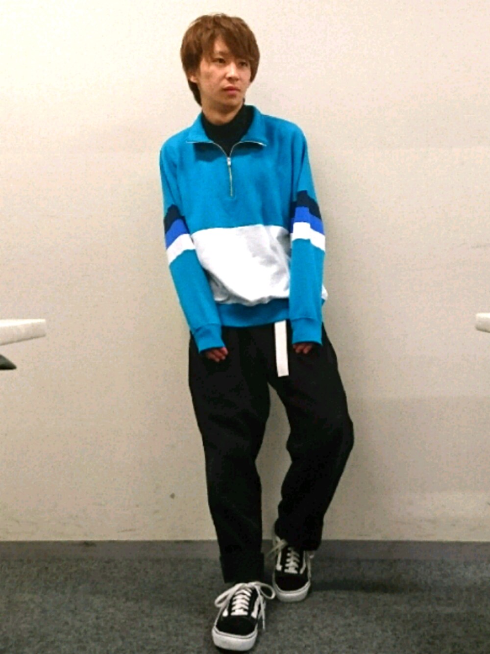 グリーン系のスウェット、ブラック系のスニーカーを着用したメンズの秋コーディネートの1枚目の写真