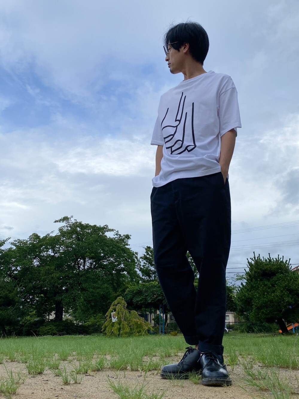 ブラック系のドレスシューズ、ブラック系のチノパンツ、その他のTシャツ/カットソーを着用したメンズの夏コーディネートの1枚目の写真
