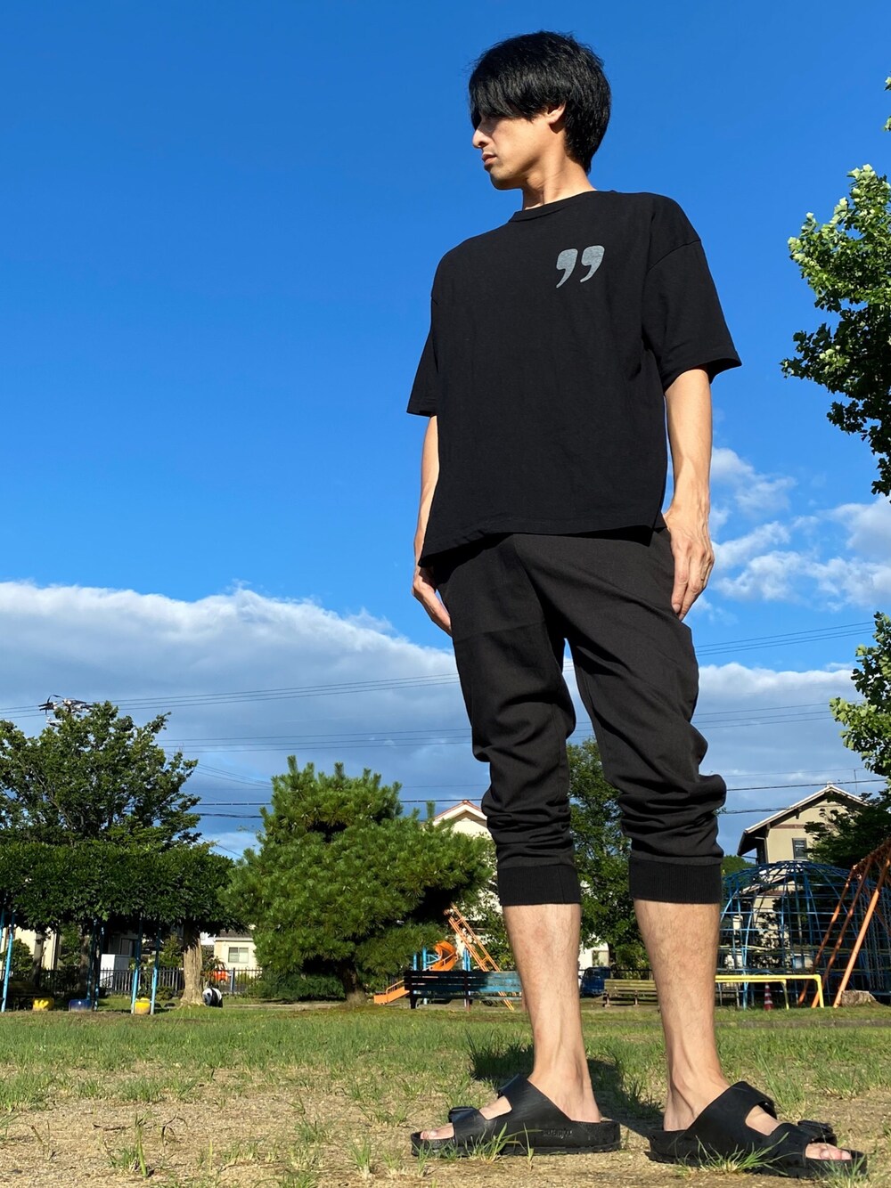 ブラック系のサンダル、ブラック系のチノパンツ、その他のTシャツ/カットソーを着用したメンズの夏コーディネートの1枚目の写真