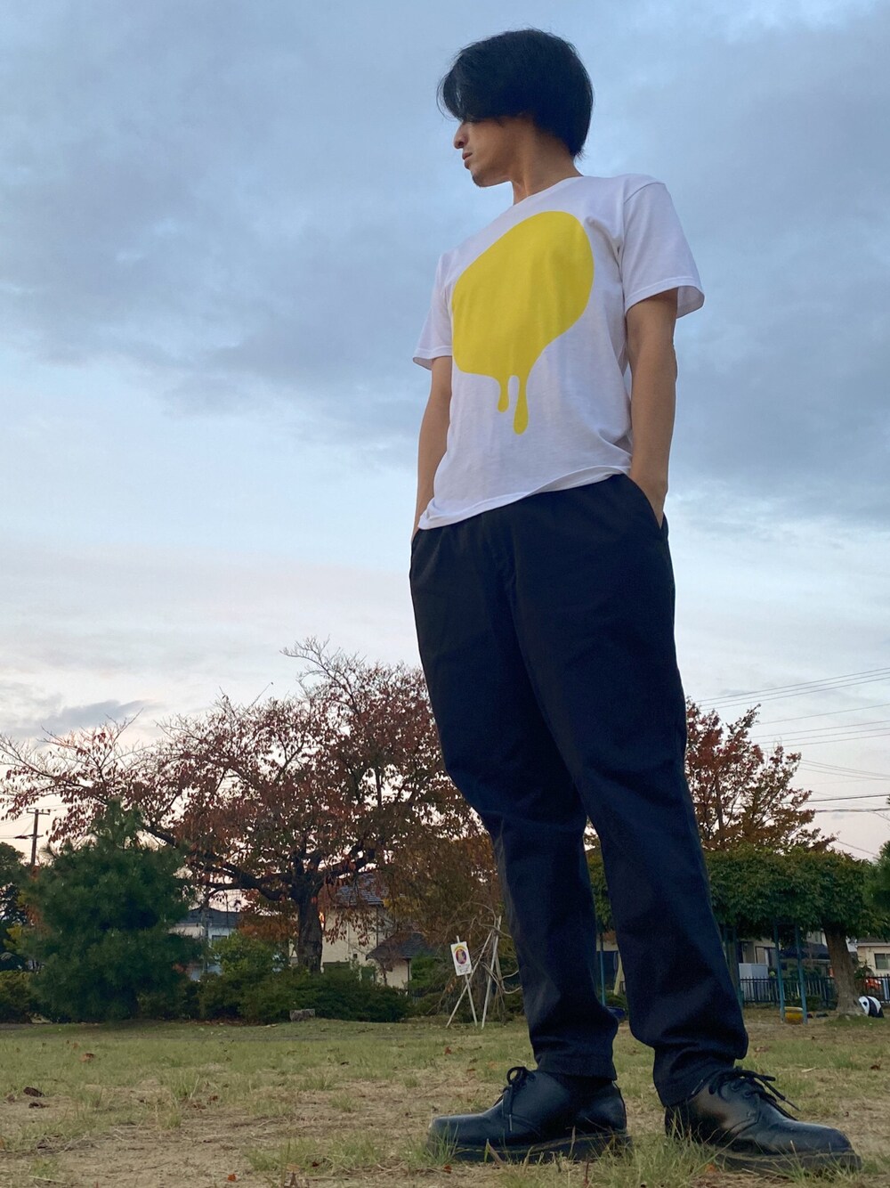 ブラック系のドレスシューズ、ブラック系のチノパンツ、その他のTシャツ/カットソーを着用したメンズの秋コーディネートの1枚目の写真