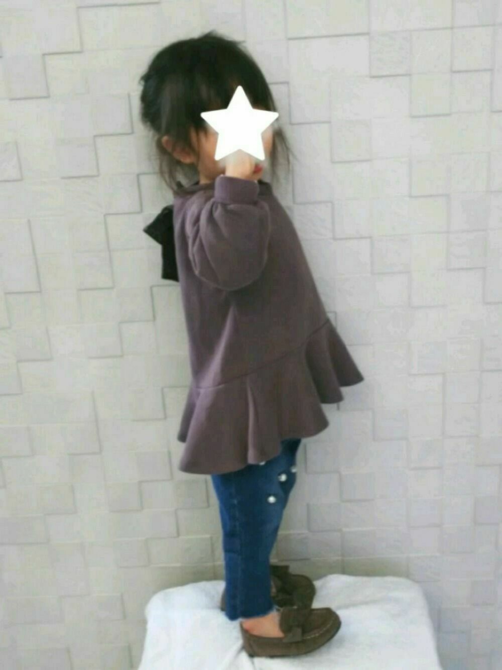 グレー系のチュニック、ブルー系のデニムパンツ、ブラウン系のモカシン/デッキシューズを着用したキッズの冬コーディネートの1枚目の写真