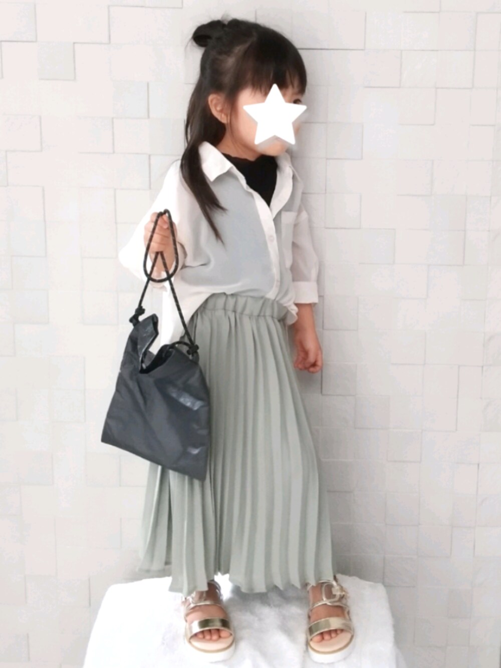 グリーン系のスカート、ブラック系のタンクトップ、ベージュ系のシャツ/ブラウスを着用したキッズの秋コーディネートの1枚目の写真