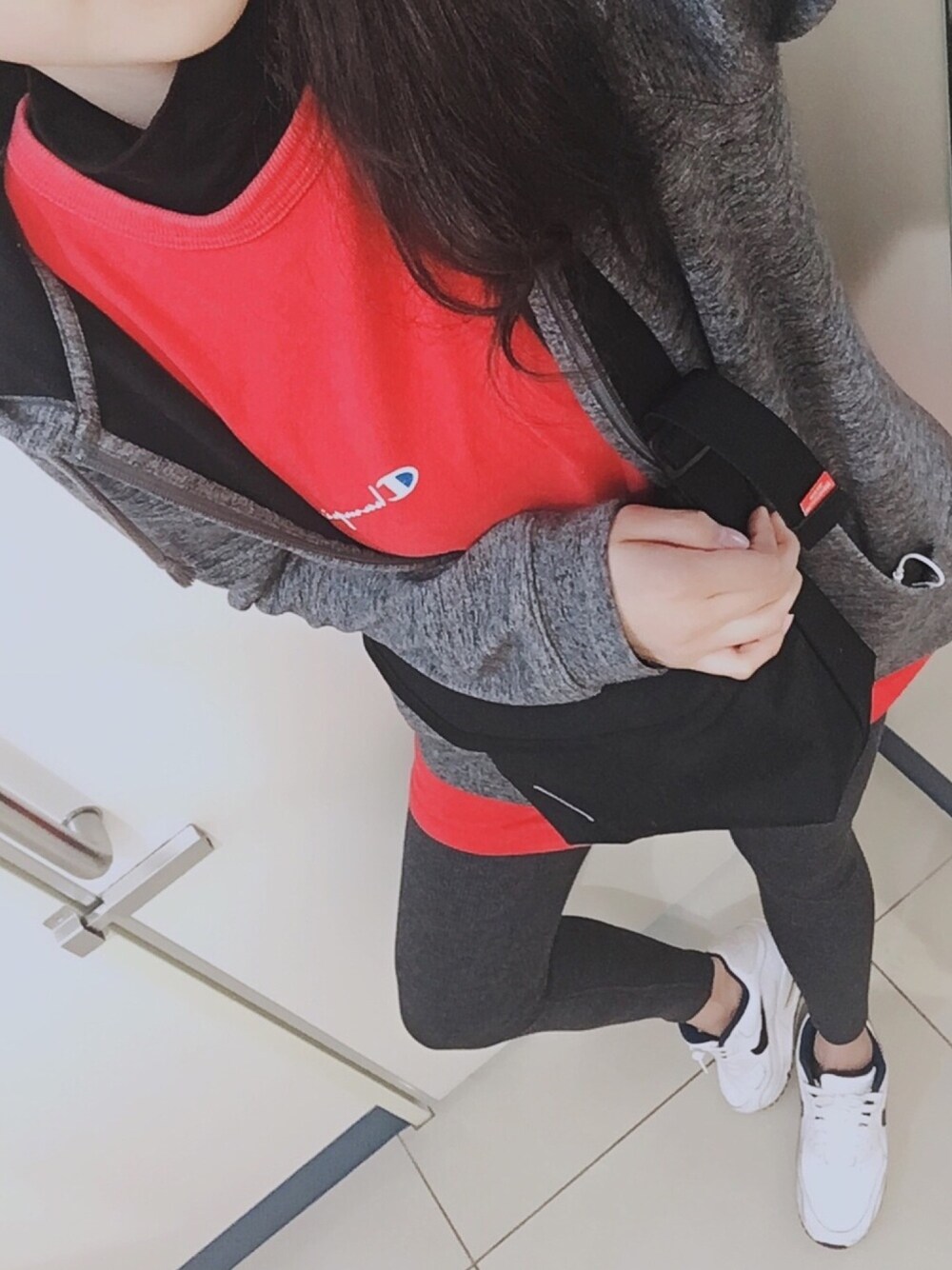 ブラック系のTシャツ/カットソー、ブルー系のショルダーバッグ、レッド系のTシャツ/カットソーを着用したレディースの春コーディネートの1枚目の写真