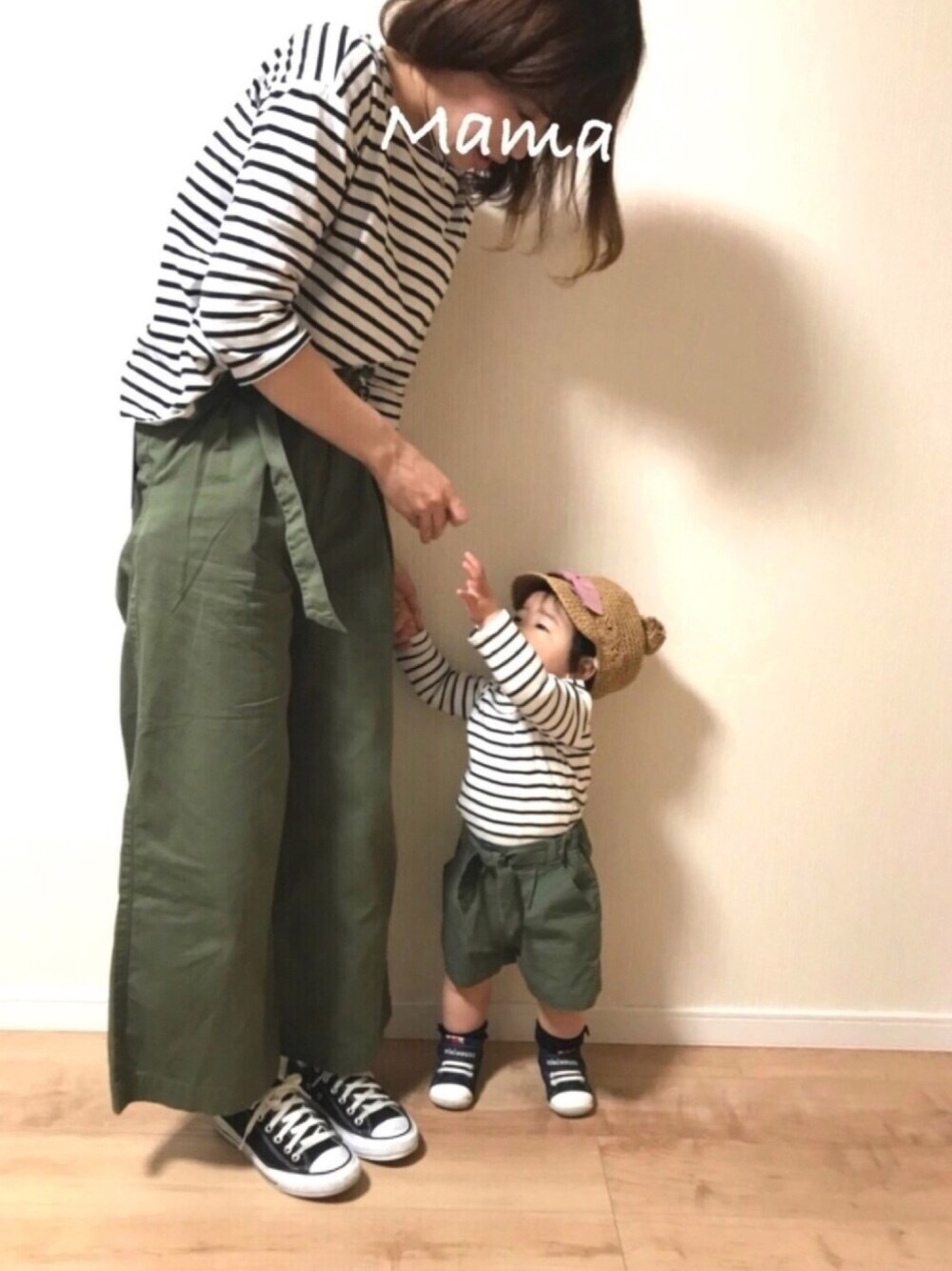 グリーン系のチノパンツ、ブラック系のTシャツ/カットソー、ホワイト系のTシャツ/カットソーを着用したレディースの春コーディネートの1枚目の写真