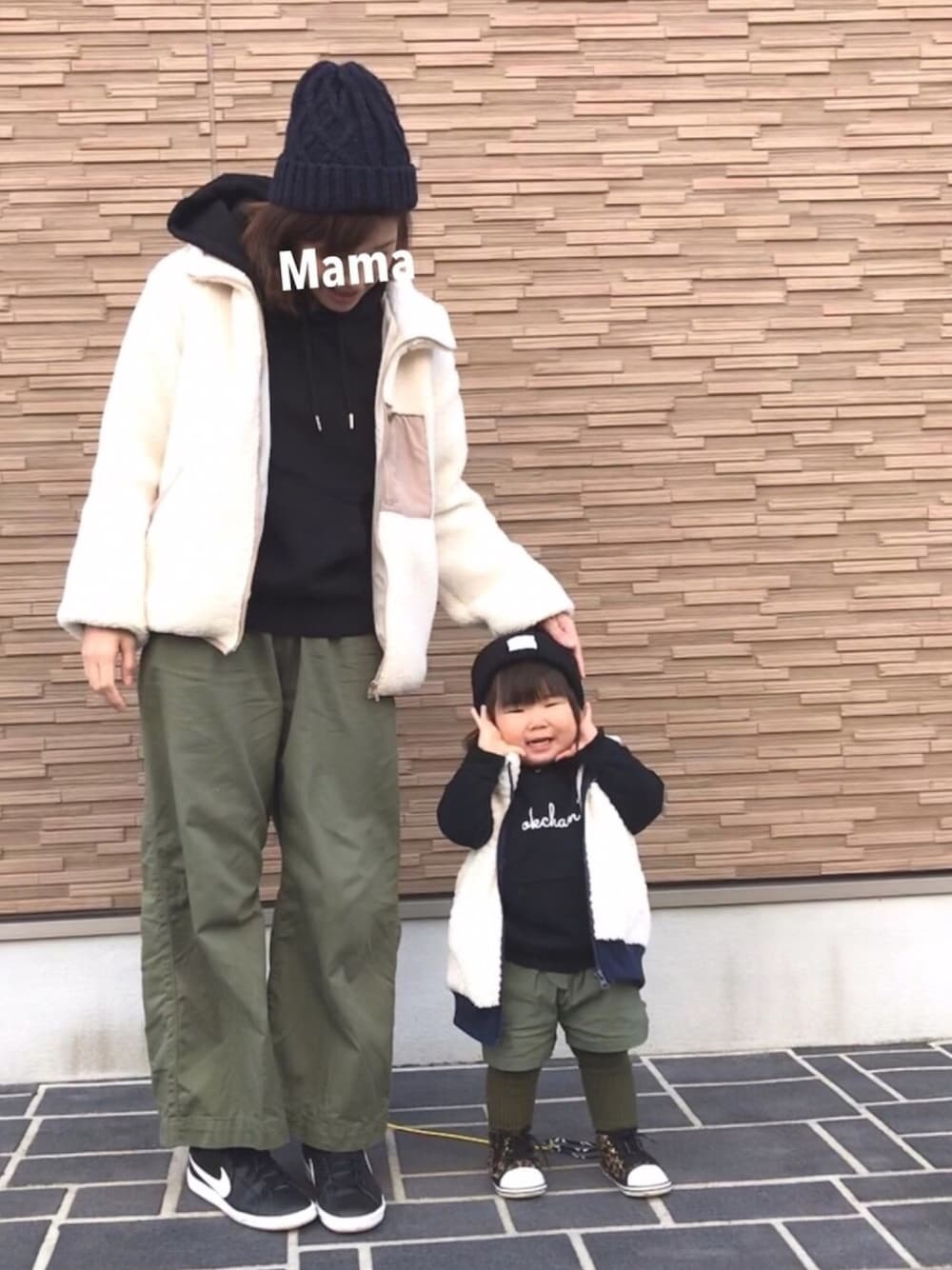 ブラック系のパーカー、グリーン系のその他パンツ、ゴールド系のスニーカーを着用したレディースの冬コーディネートの1枚目の写真