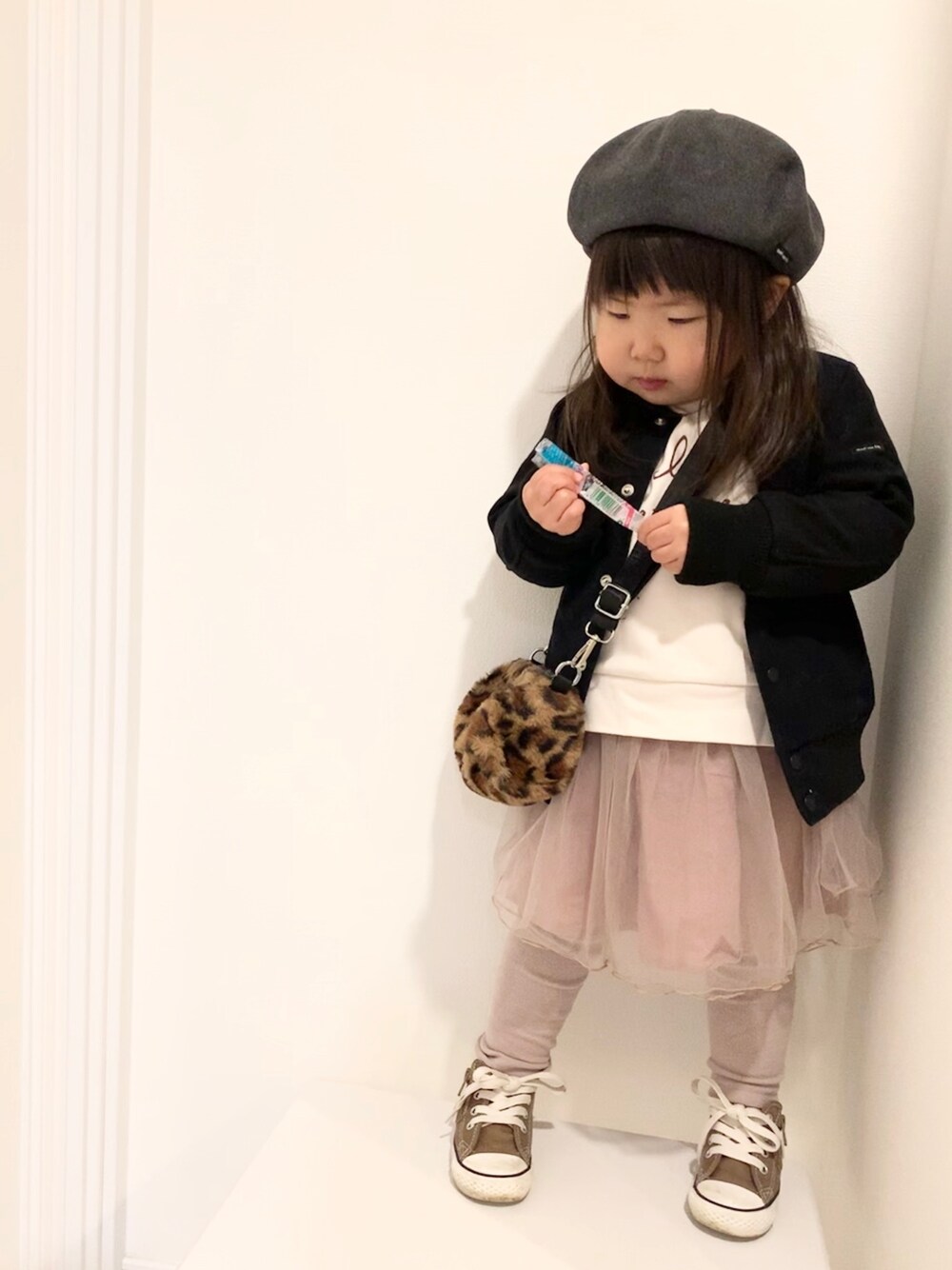 ブラック系のスタジャン、ホワイト系のスウェット、ブラウン系のショルダーバッグを着用したキッズの冬コーディネートの1枚目の写真