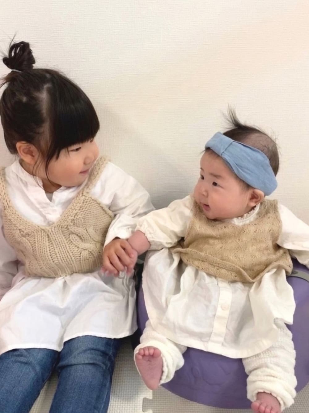 ベージュ系のシャツ/ブラウス、ピンク系のワンピース、ブルー系のデニムパンツを着用したキッズの春コーディネートの1枚目の写真