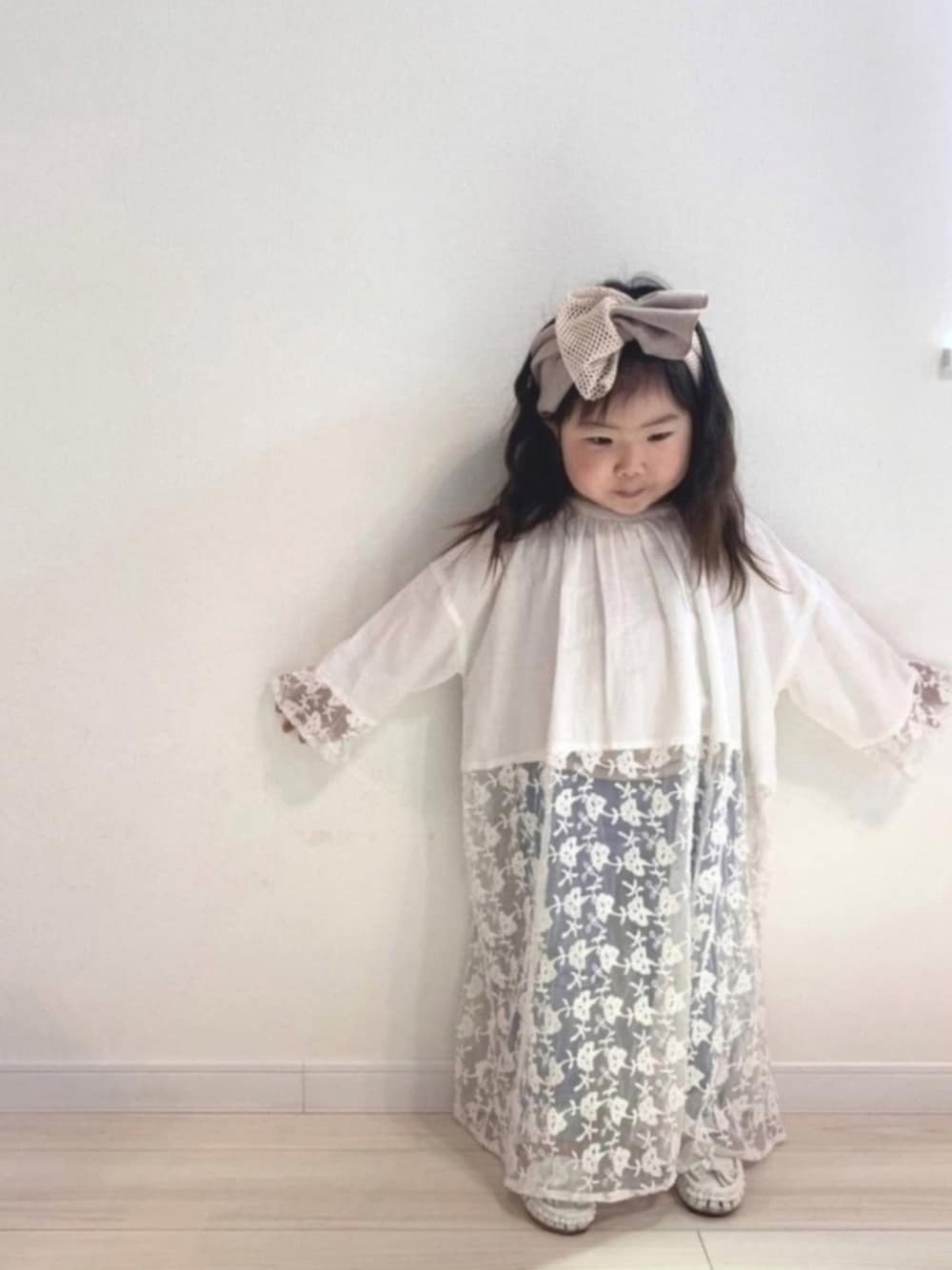 ホワイト系のワンピース、ピンク系のタンクトップ、ブルー系のデニムパンツを着用したキッズの春コーディネートの1枚目の写真