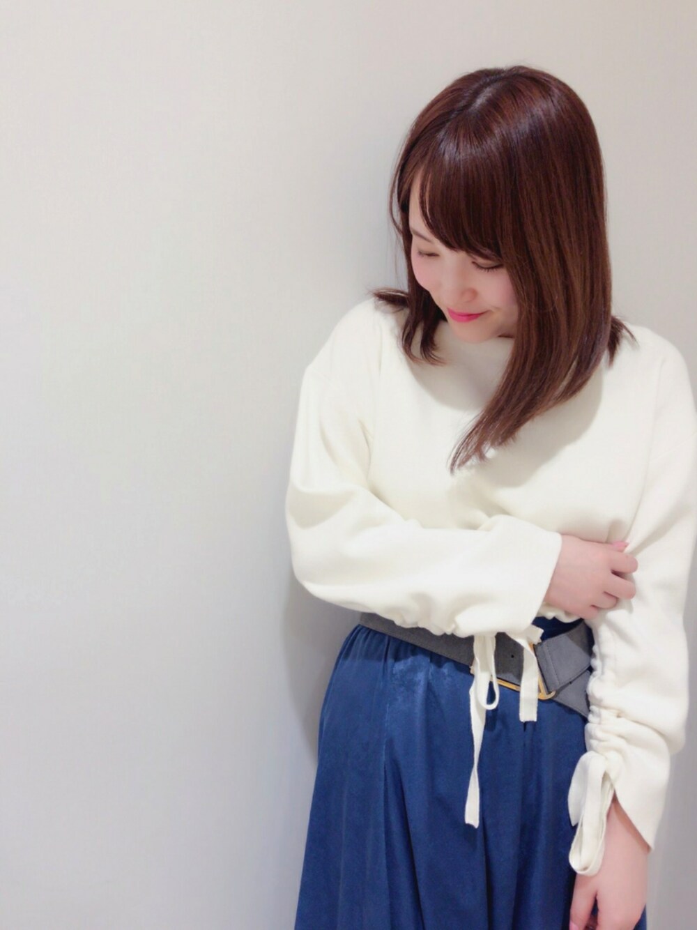 ホワイト系のニット/セーター、ブルー系のスカートを着用したレディースの冬コーディネートの1枚目の写真