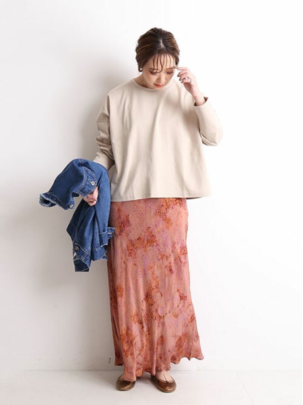 ベージュ系のTシャツ/カットソー、ピンク系のスカート、ブルー系のデニムジャケットを着用したレディースの秋コーディネートの1枚目の写真