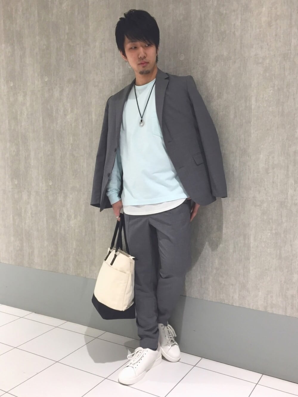 グレー系のテーラードジャケット、ブルー系のTシャツ/カットソー、グレー系のスラックスを着用したメンズの春コーディネートの1枚目の写真