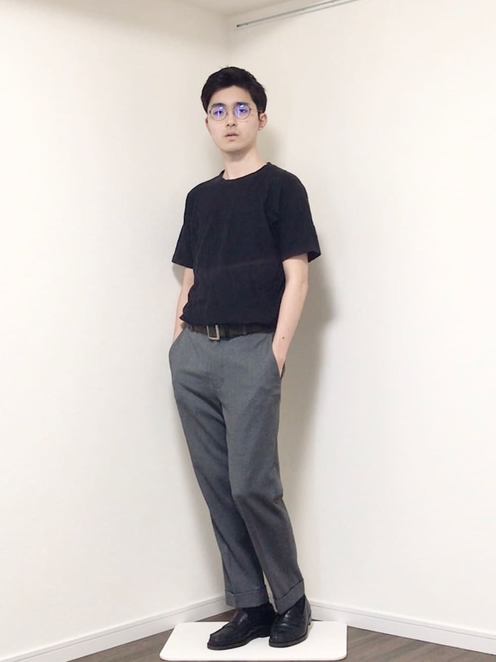 ブラック系のTシャツ/カットソー、グレー系のスラックス、ブラック系のローファーを着用したメンズの春コーディネートの1枚目の写真