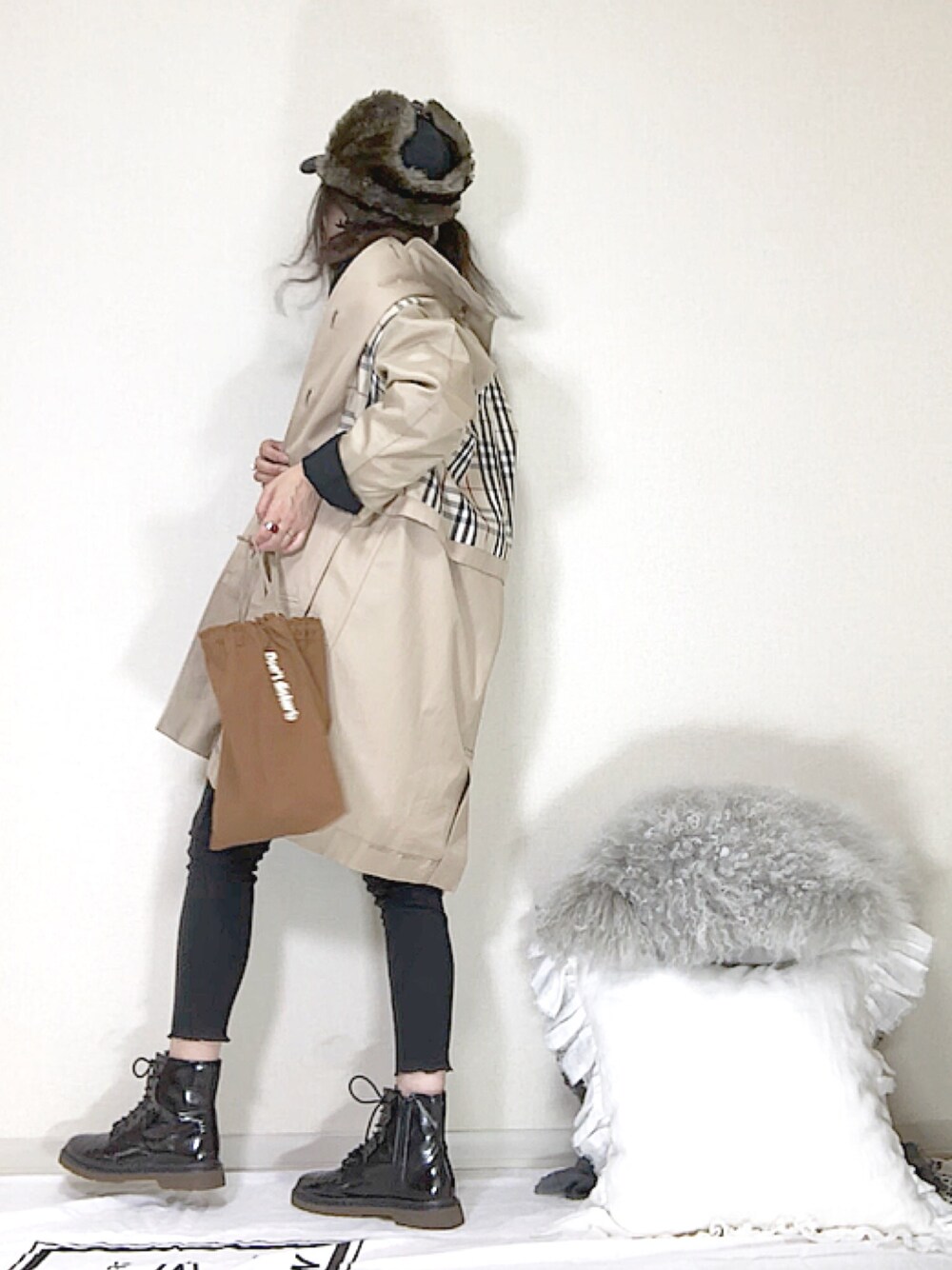 ブラウン系のハンドバッグ、ブラック系のパンツ、ブラック系のブーツを着用したレディースの秋コーディネートの1枚目の写真