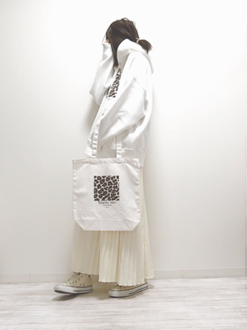 ホワイト系のパーカー、ホワイト系のトートバッグ、ホワイト系のスカートを着用したレディースの春コーディネートの1枚目の写真