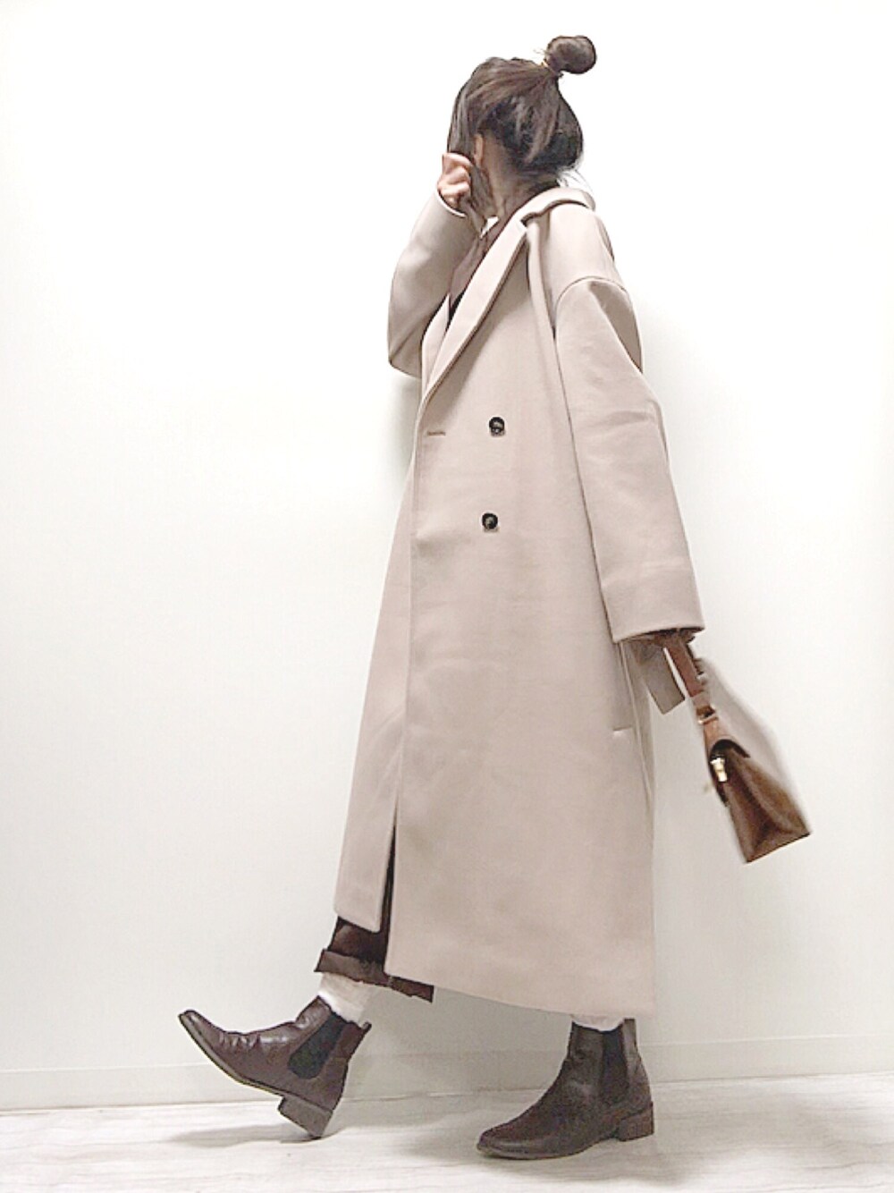 ピンク系のチェスターコート、ブラウン系のテーラードジャケット、ブラウン系のショルダーバッグを着用したレディースの秋コーディネートの1枚目の写真