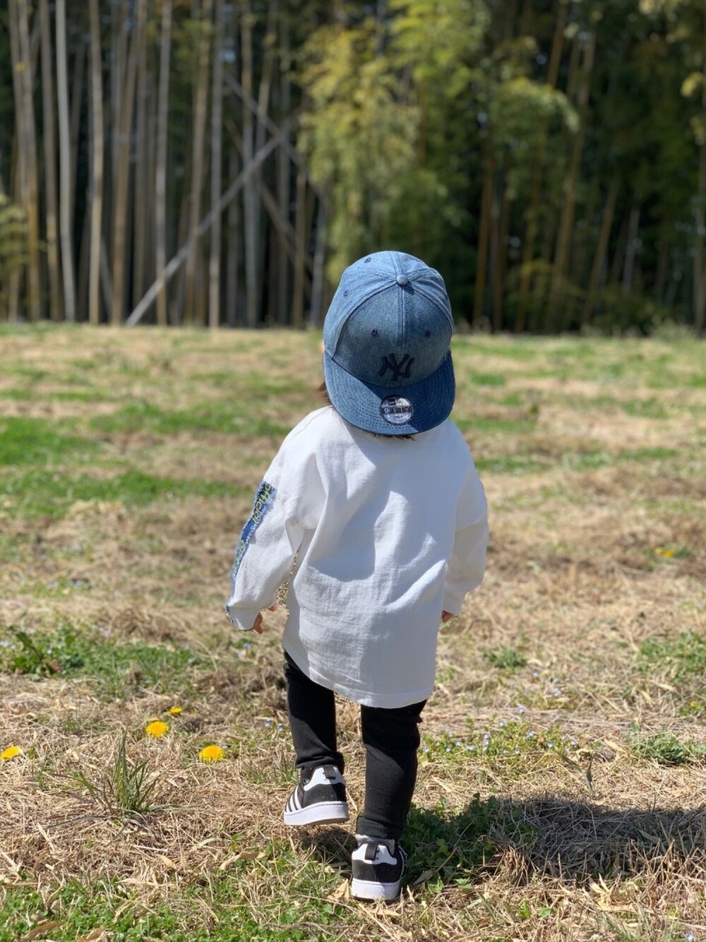ホワイト系のTシャツ/カットソー、ブラック系のパンツ、ブラック系のスニーカーを着用したキッズの春コーディネートの1枚目の写真