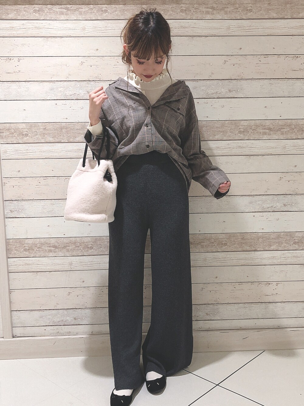 ホワイト系のニット/セーター、ブラック系のシャツ/ブラウス、グレー系のパンツを着用したレディースの秋コーディネートの1枚目の写真