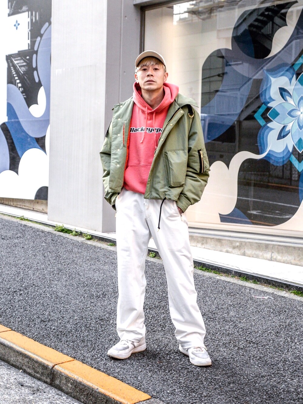 ピンク系のパーカー、グリーン系のブルゾン、ホワイト系のその他パンツを着用したメンズの春コーディネートの1枚目の写真