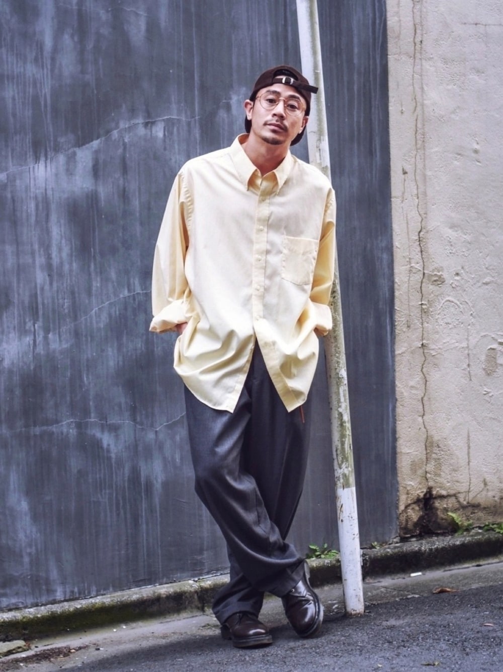 イエロー系のシャツ/ブラウス、グレー系のスラックス、ブラウン系のブーツを着用したメンズの春コーディネートの1枚目の写真