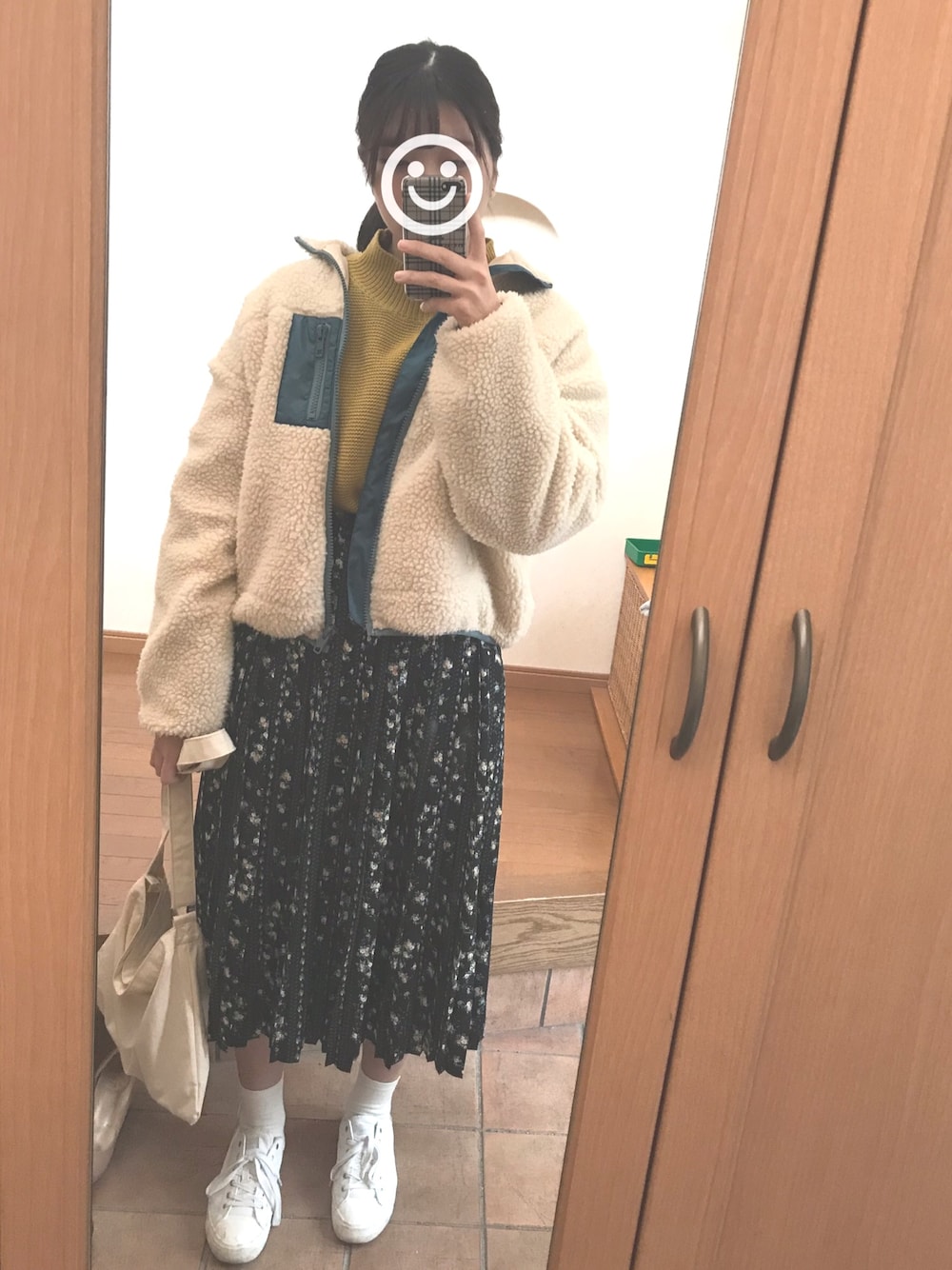 ベージュ系のブルゾン、イエロー系のニット/セーター、ブラック系のスカートを着用したレディースの冬コーディネートの1枚目の写真