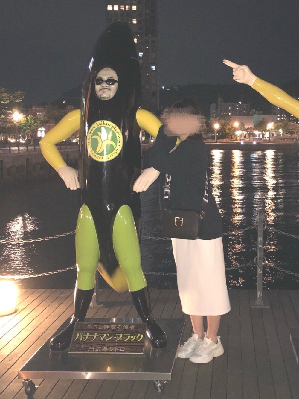 ブラック系のショルダーバッグ、ホワイト系のスカート、ホワイト系のスニーカーを着用したレディースの春コーディネートの1枚目の写真