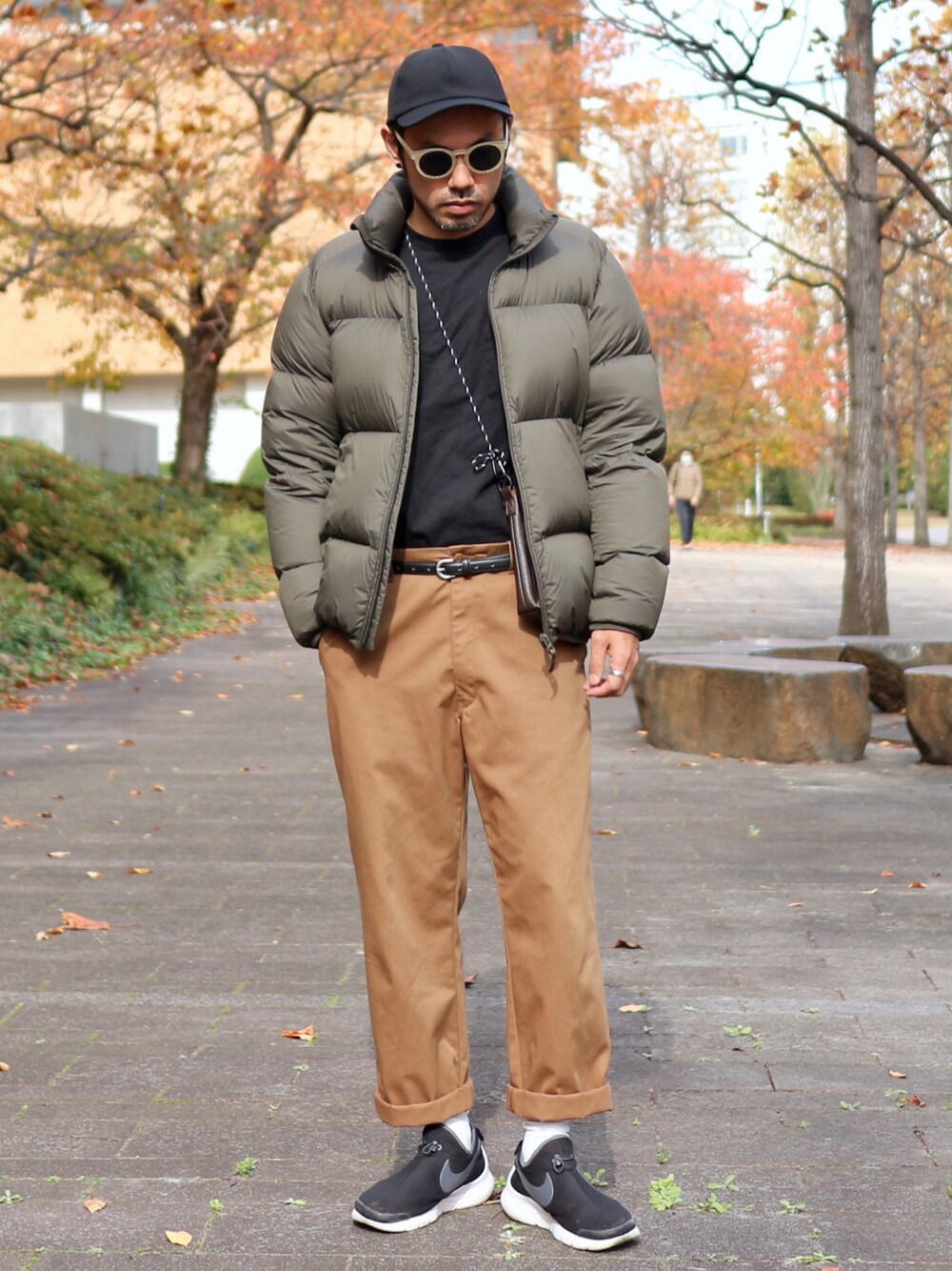 グリーン系のダウンジャケット/コート、ブラック系のTシャツ/カットソー、ブラウン系のチノパンツを着用したメンズの冬コーディネートの1枚目の写真