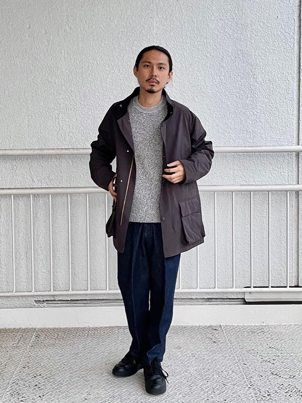 ブラック系のスニーカー、ブルー系のデニムパンツ、グレー系のニット/セーターを着用したメンズの秋コーディネートの1枚目の写真
