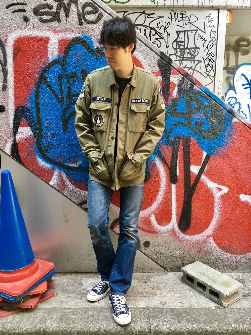 グリーン系のミリタリージャケット、ブラック系のTシャツ/カットソーを着用したメンズの春コーディネートの1枚目の写真