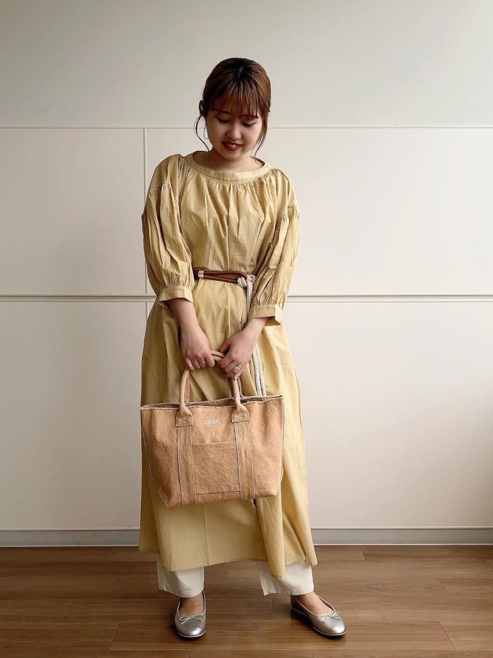 シルバー系のバレエシューズ、イエロー系のワンピース、ベージュ系のタンクトップを着用したレディースの春コーディネートの1枚目の写真