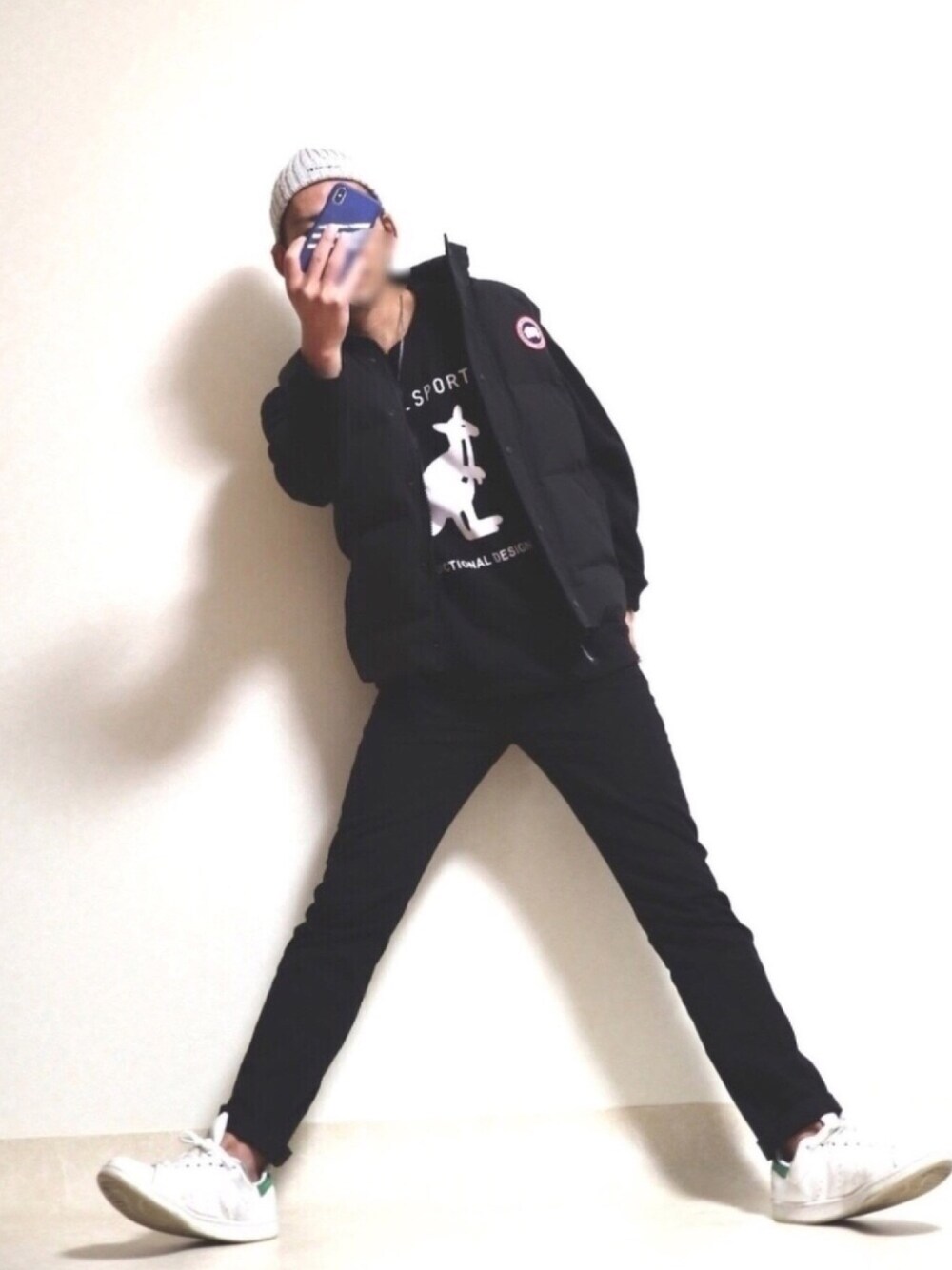 ブラック系のスウェット、ブラック系のデニムパンツ、ホワイト系のスニーカーを着用したメンズの秋コーディネートの1枚目の写真