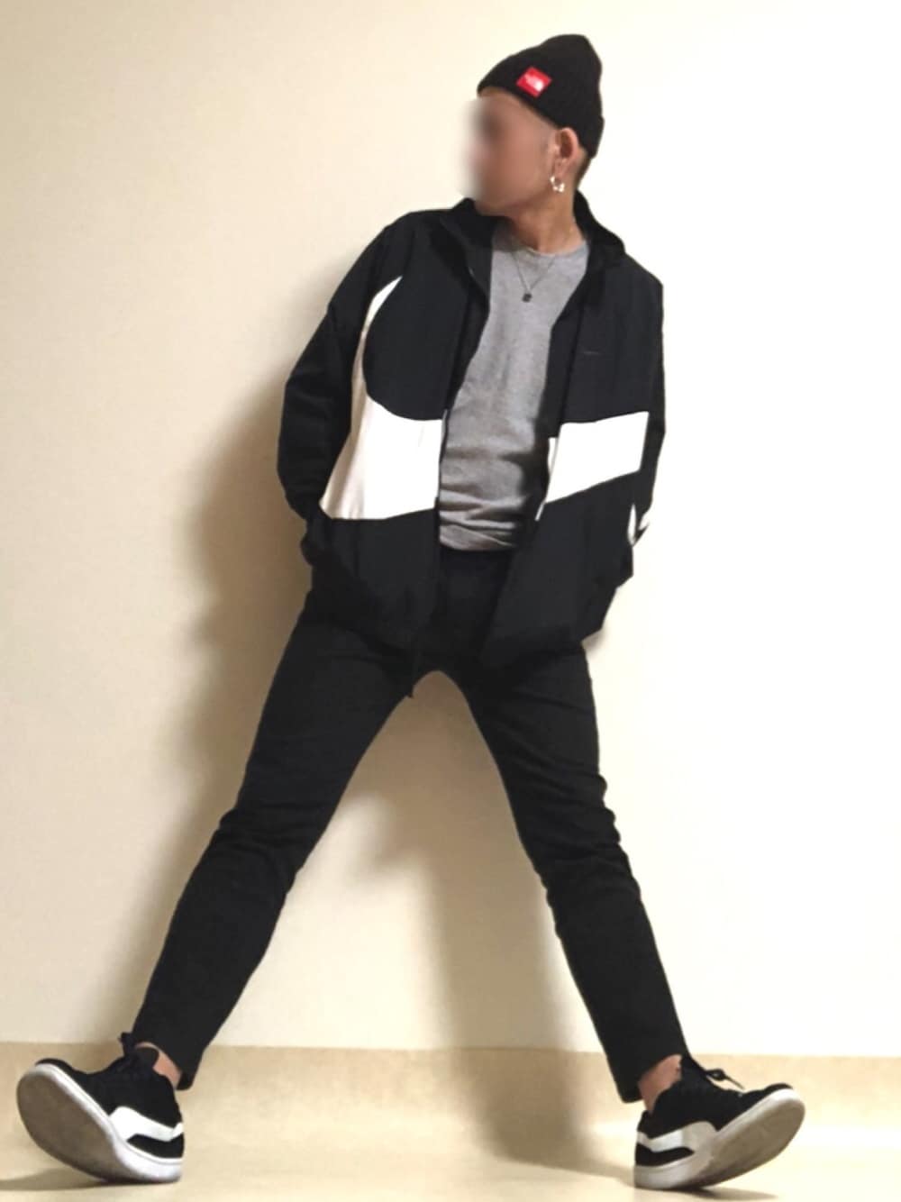 ブラック系のスニーカー、ブラック系のデニムパンツ、ブラック系のナイロンジャケットを着用したメンズの春コーディネートの1枚目の写真