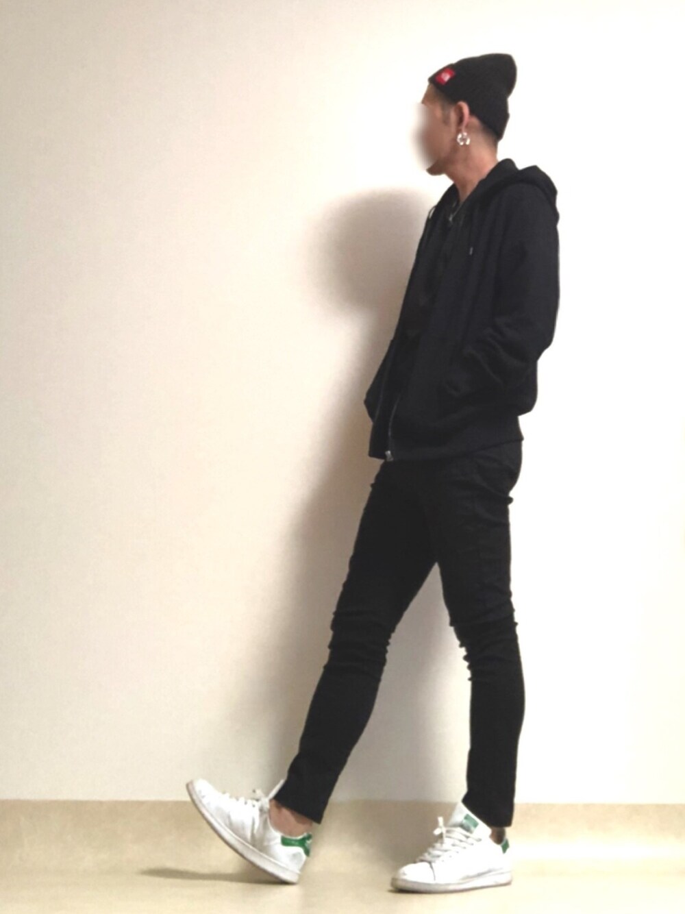 ホワイト系のスニーカー、ブラック系のデニムパンツ、ブラック系のパーカーを着用したメンズの春コーディネートの1枚目の写真